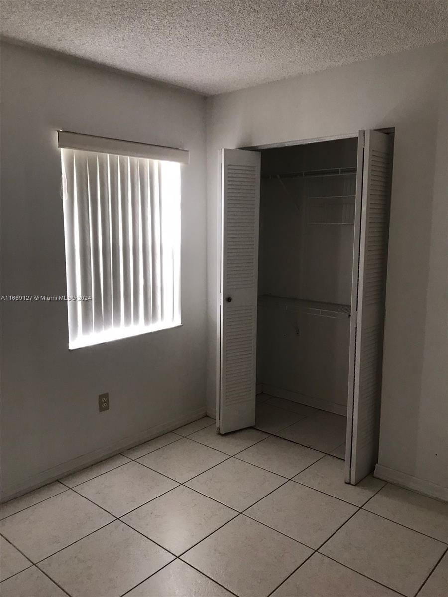 423 Northeast 210th Cir Terrace, Unit 10425 Miami, FL 33179 - Photo 24 of 37 a view of an empty room with window and a bathroom