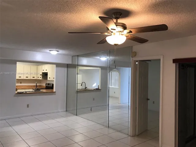a kitchen with granite countertop a sink a stove and refrigerator