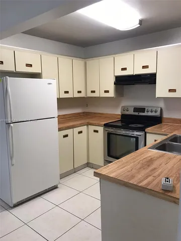 a kitchen with stainless steel appliances a stove a sink and a refrigerator