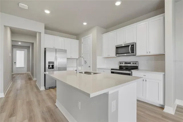 a kitchen with refrigerator and a stove top oven