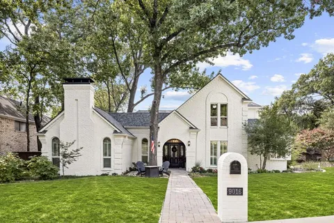 a front view of a house with a yard and trees
