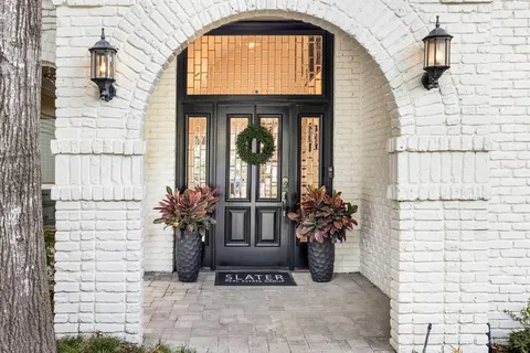 a potted plant sitting in front of a brick house with a small yard
