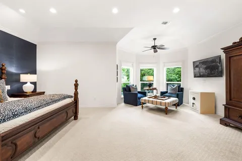 a bedroom with furniture and a large window