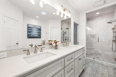 a bathroom with double sink and a mirror