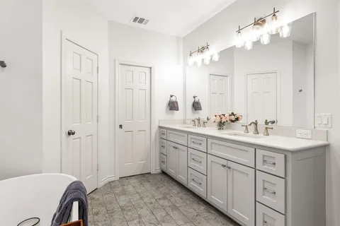 a bathroom with a double vanity sink mirror and