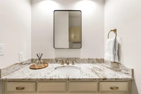 a bathroom with sink granite and a mirror