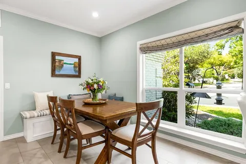 a dining room with furniture and a floor to ceiling window