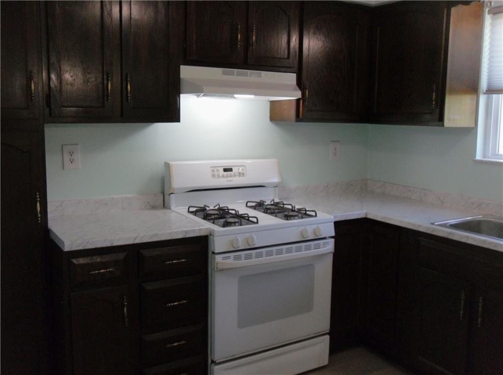 419 Streets Run Road Pittsburgh, PA 15236 - Photo 4 of 46 a kitchen with granite countertop wood cabinets and a stove top oven
