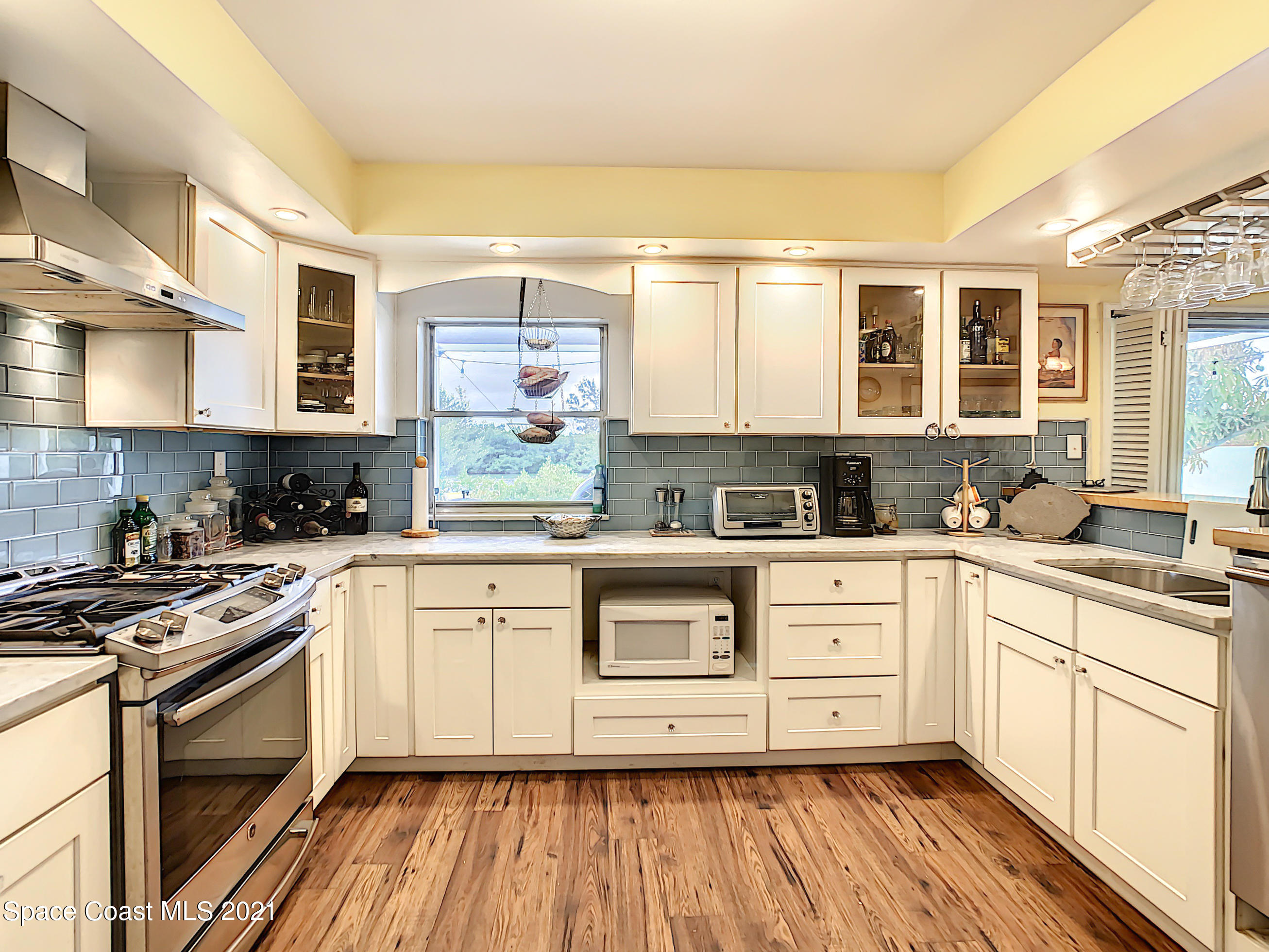 738 Nassau Road Cocoa Beach, FL 32931 - Photo 12 of 26 a kitchen with stainless steel appliances granite countertop a stove a sink and white cabinets