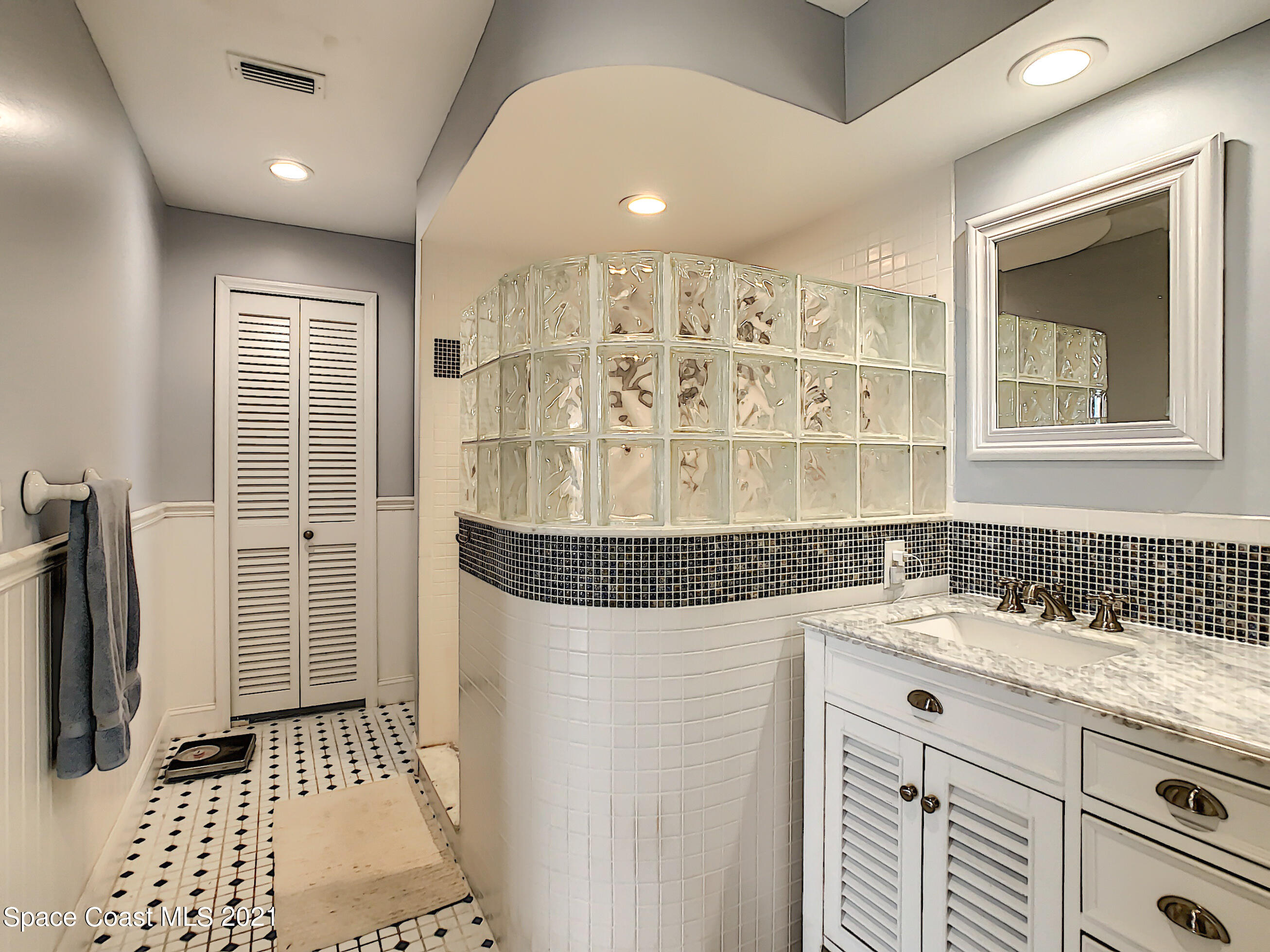 738 Nassau Road Cocoa Beach, FL 32931 - Photo 17 of 26 a bathroom with a sink a mirror and a shower