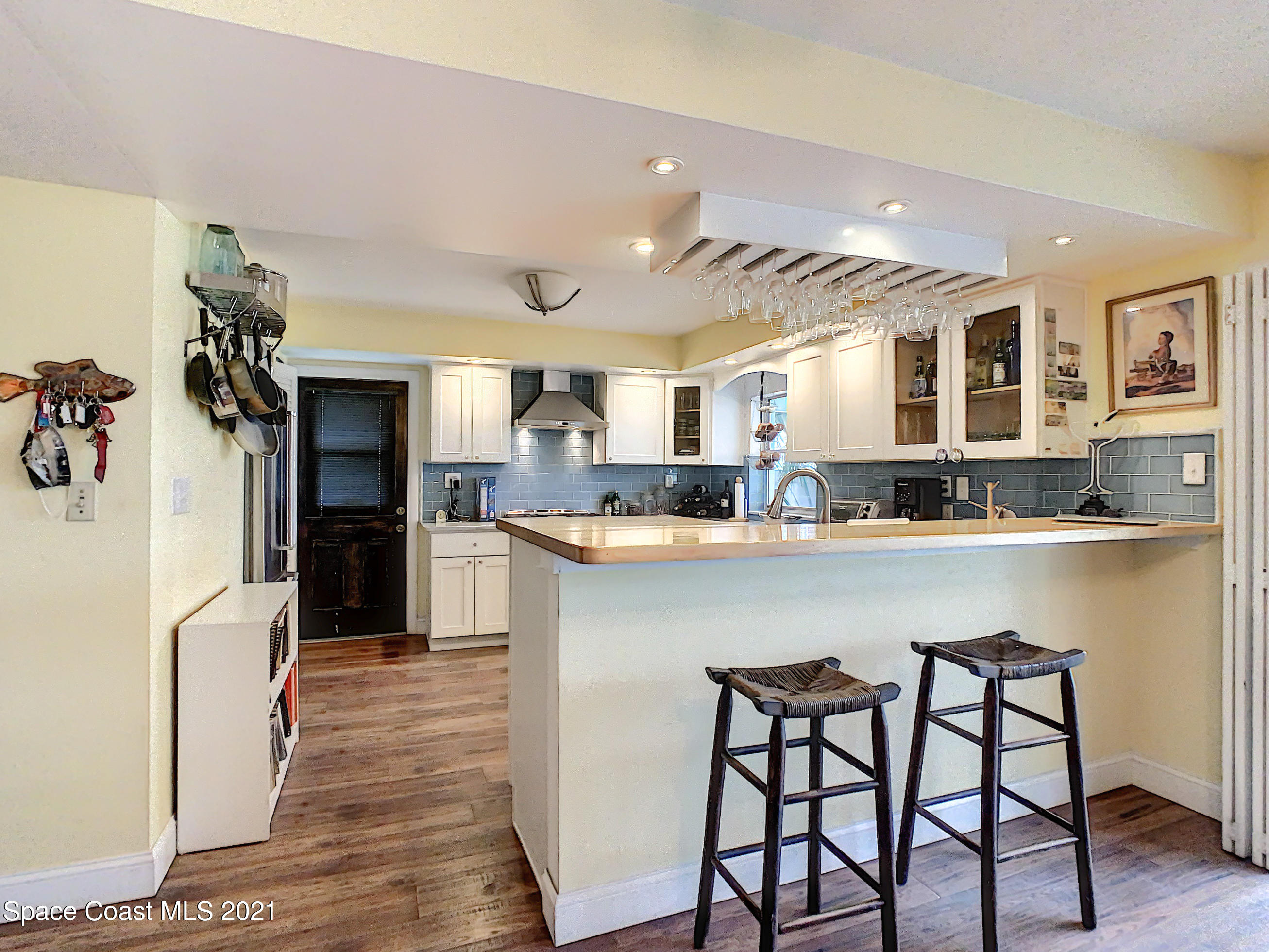 738 Nassau Road Cocoa Beach, FL 32931 - Photo 9 of 26 a kitchen with a table chairs refrigerator and microwave