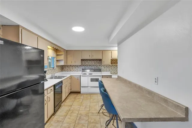 a kitchen with a sink refrigerator and cabinets