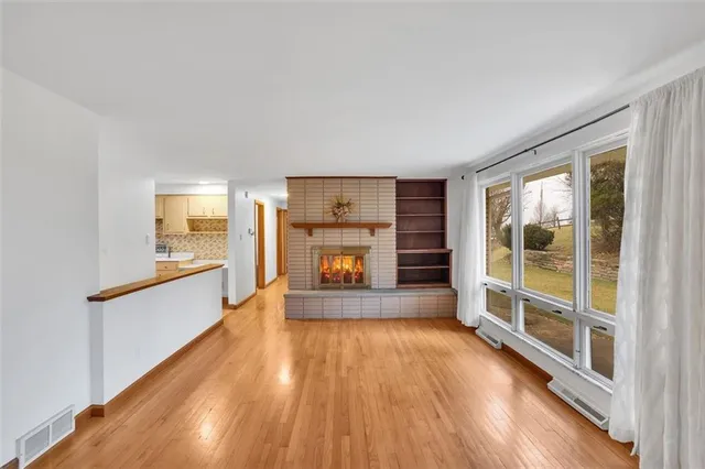 a view of an empty room with a window and fire place