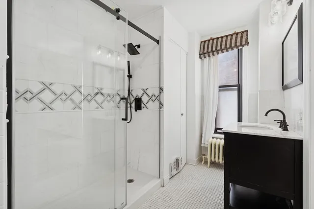 a bathroom with a double vanity sink mirror and shower