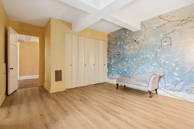 a view of a room with wooden floor and bench