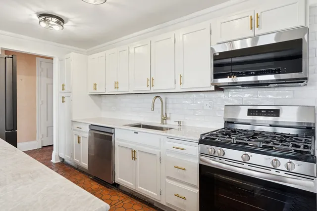 a kitchen with stainless steel appliances granite countertop a stove and a microwave