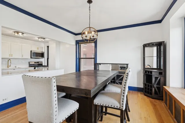 a dining room with furniture a chandelier and wooden floor