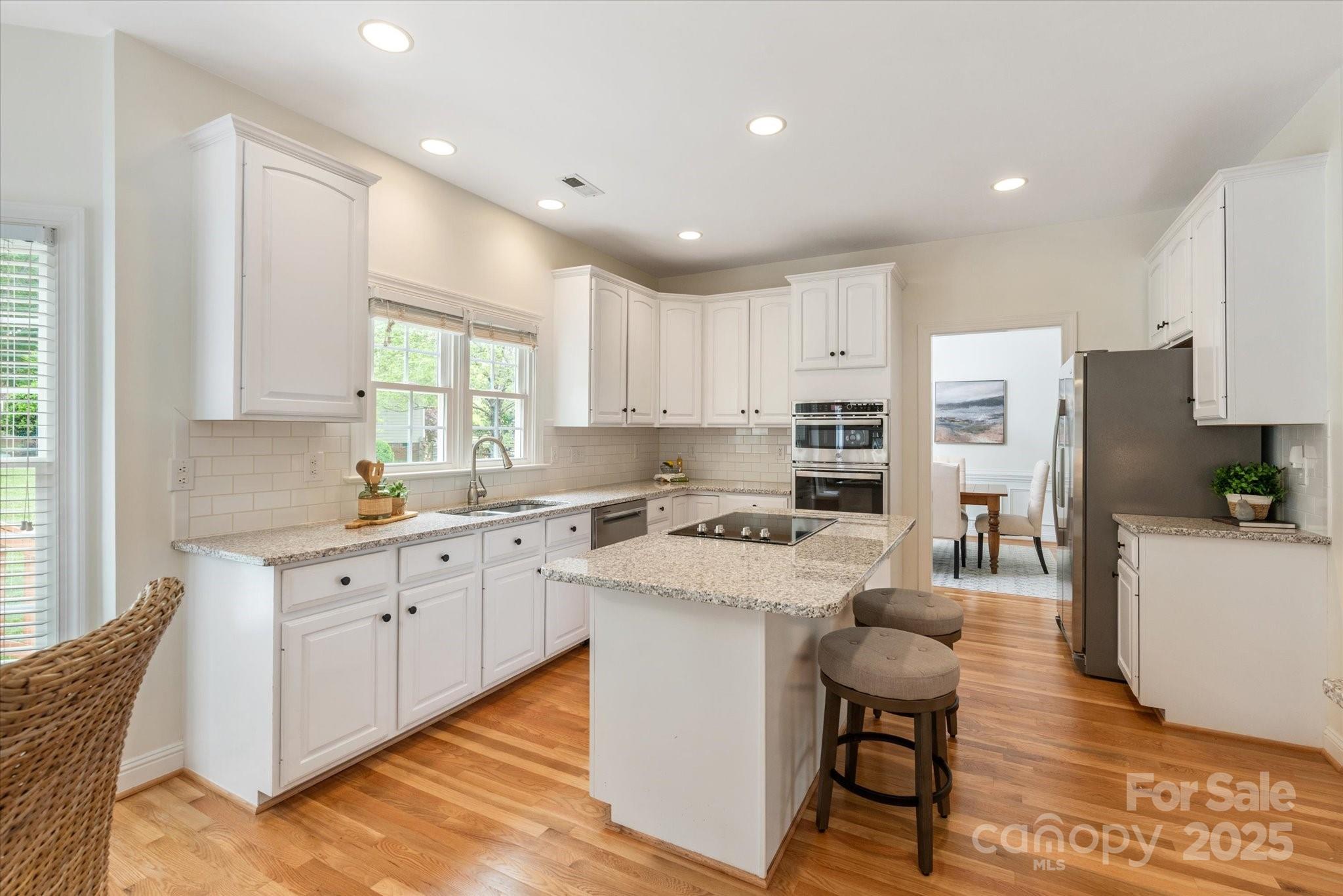1006 Baldwin Lane Waxhaw, NC 28173 - Photo 11 of 42 a kitchen with a stove a sink a refrigerator a center island and a window