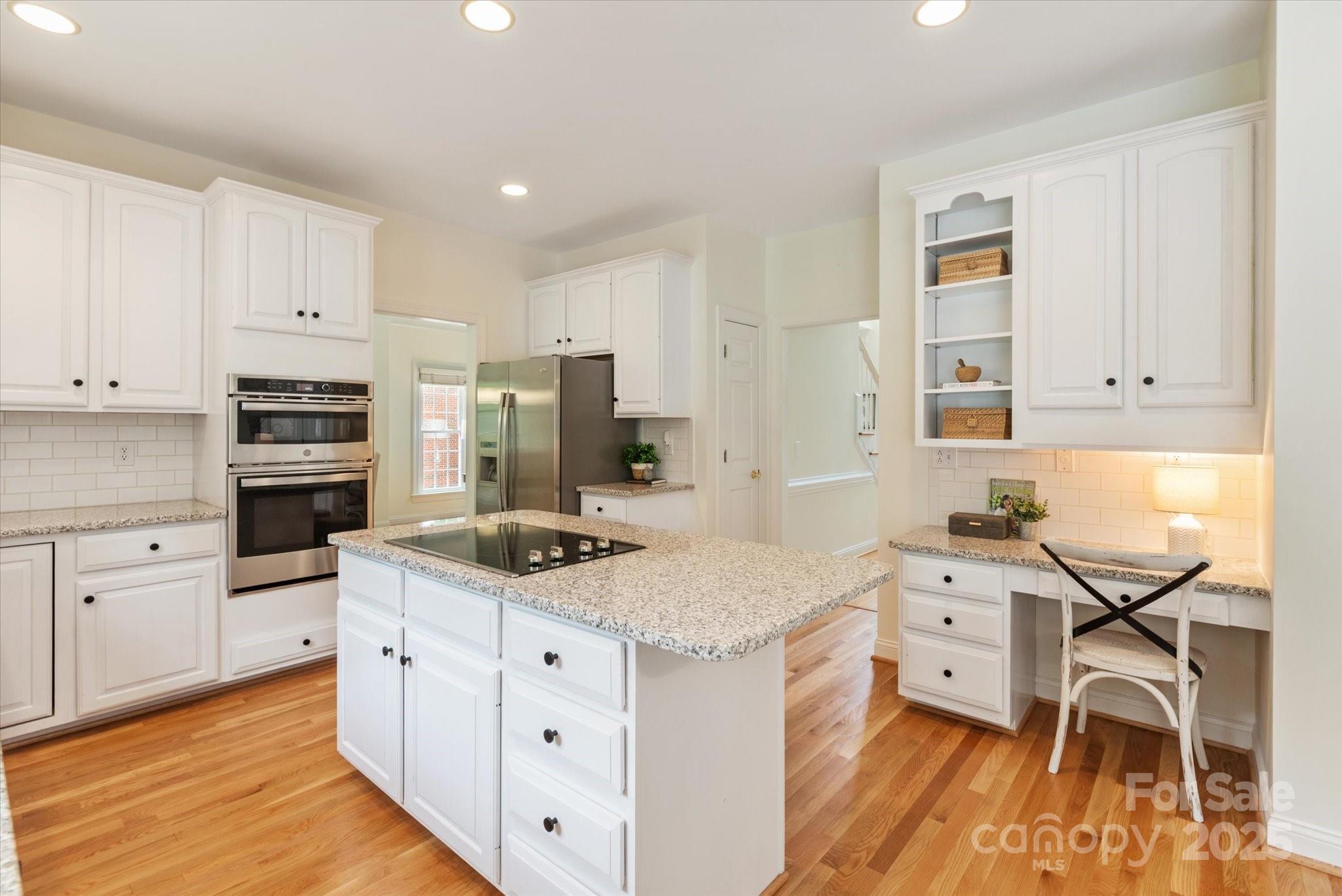 1006 Baldwin Lane Waxhaw, NC 28173 - Photo 12 of 42 a kitchen with granite countertop a sink stove cabinets and wooden floor