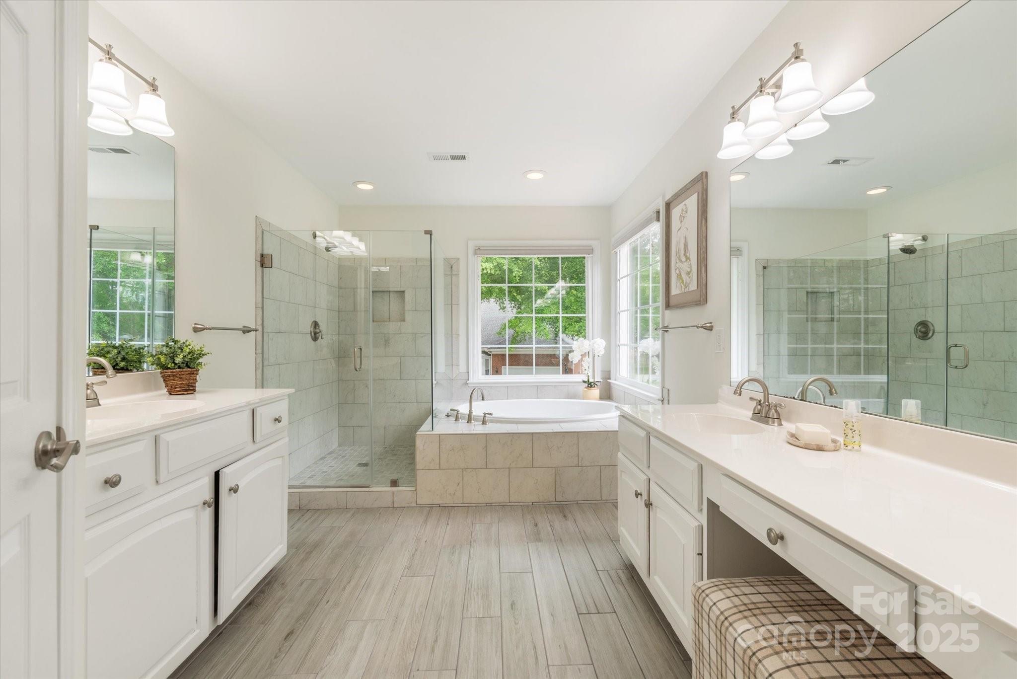 1006 Baldwin Lane Waxhaw, NC 28173 - Photo 27 of 42 a large white bathroom with a large tub sink shower and mirror