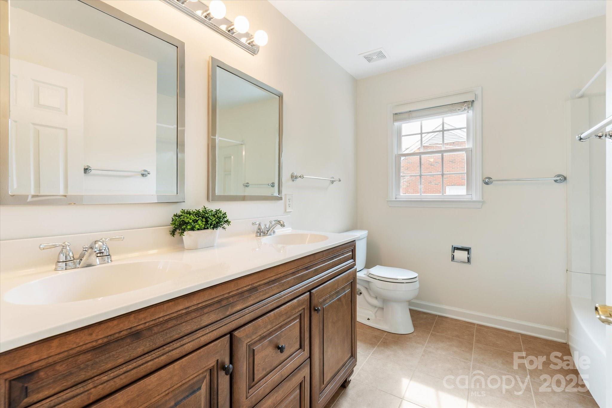 1006 Baldwin Lane Waxhaw, NC 28173 - Photo 31 of 42 a bathroom with a sink a toilet and a mirror