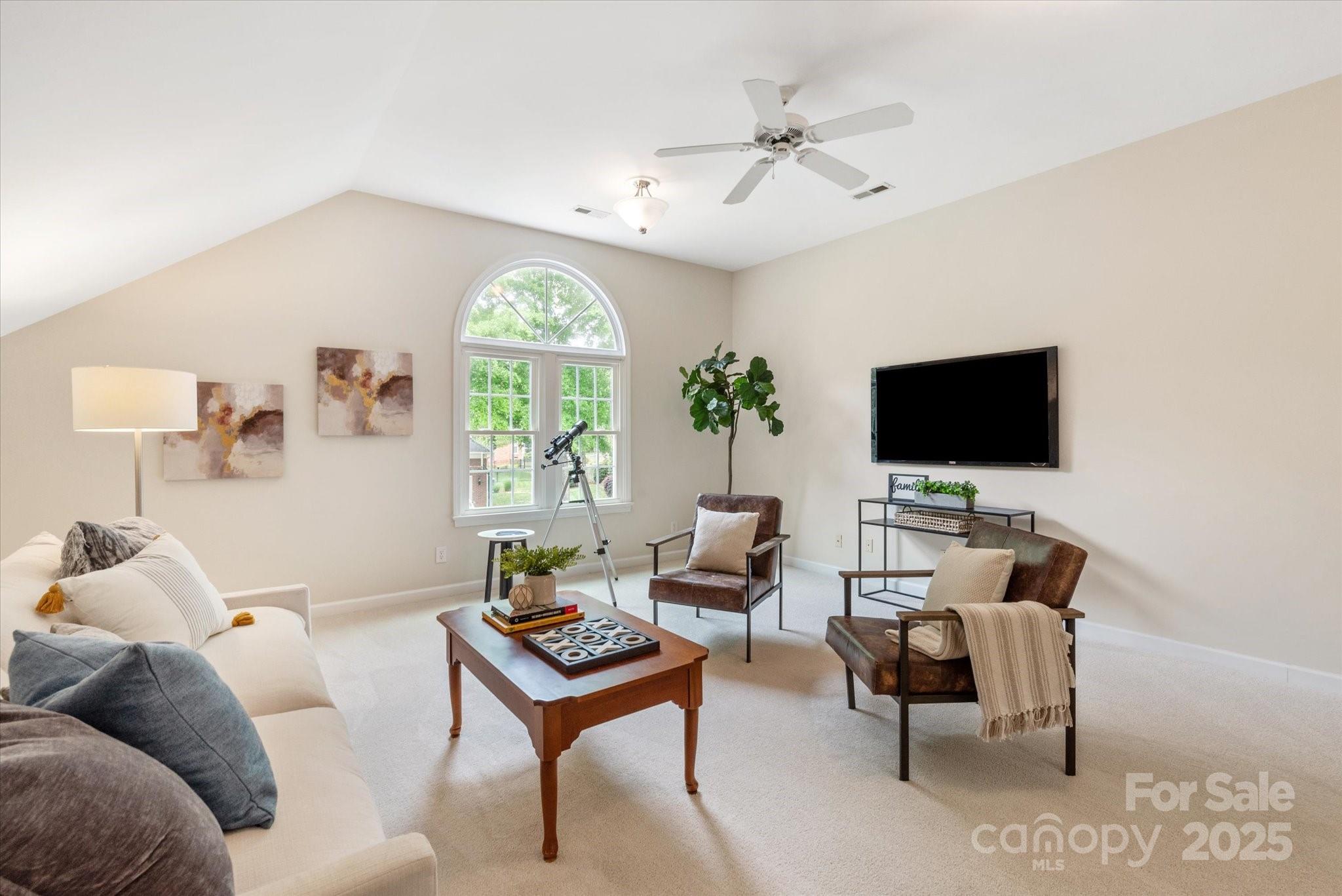 1006 Baldwin Lane Waxhaw, NC 28173 - Photo 35 of 42 a living room with furniture a large window and a flat screen tv