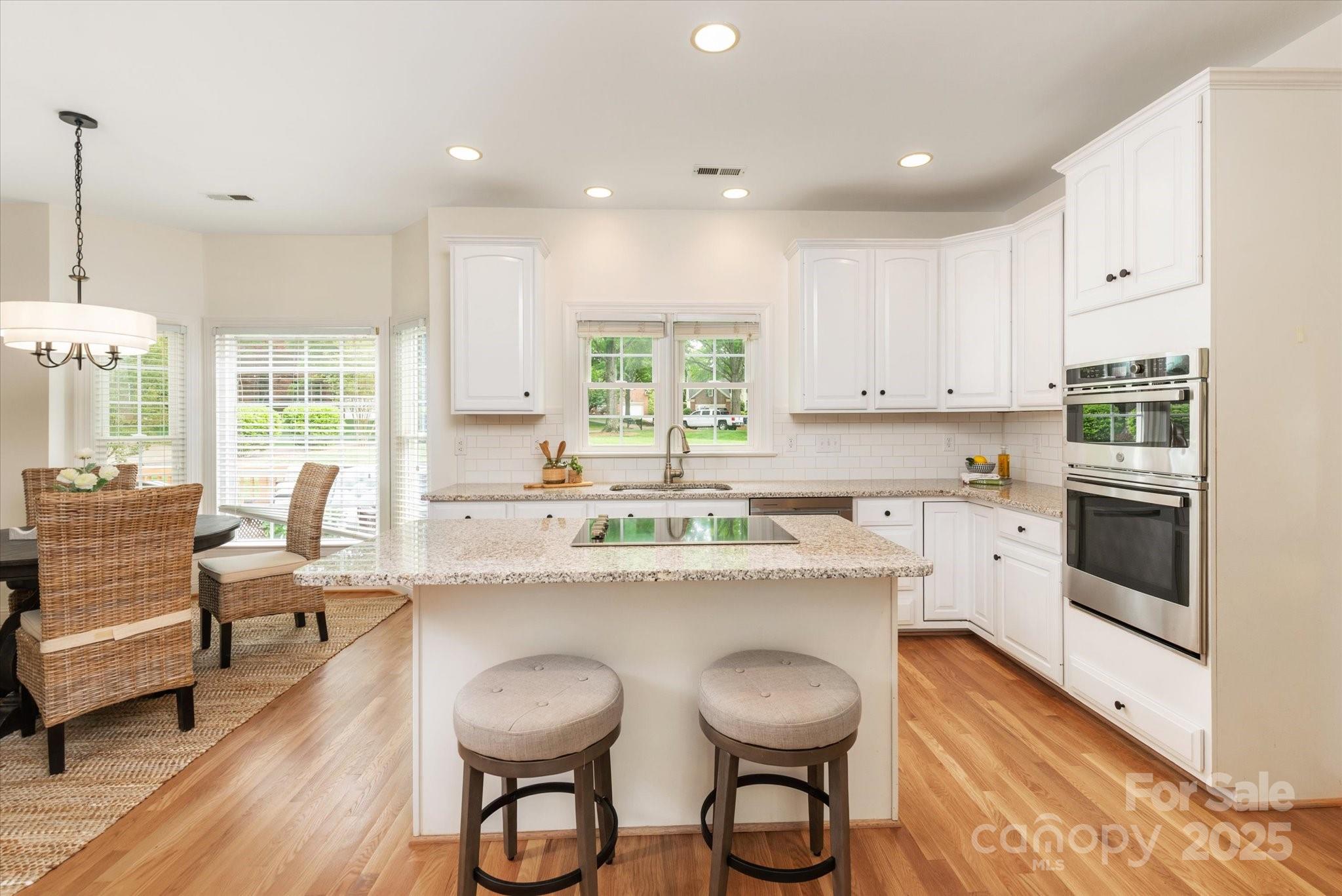 1006 Baldwin Lane Waxhaw, NC 28173 - Photo 10 of 42 a kitchen with stainless steel appliances granite countertop a white cabinets and wooden floor