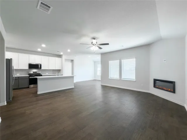 a view of a livingroom with a ceiling fan and wooden floor