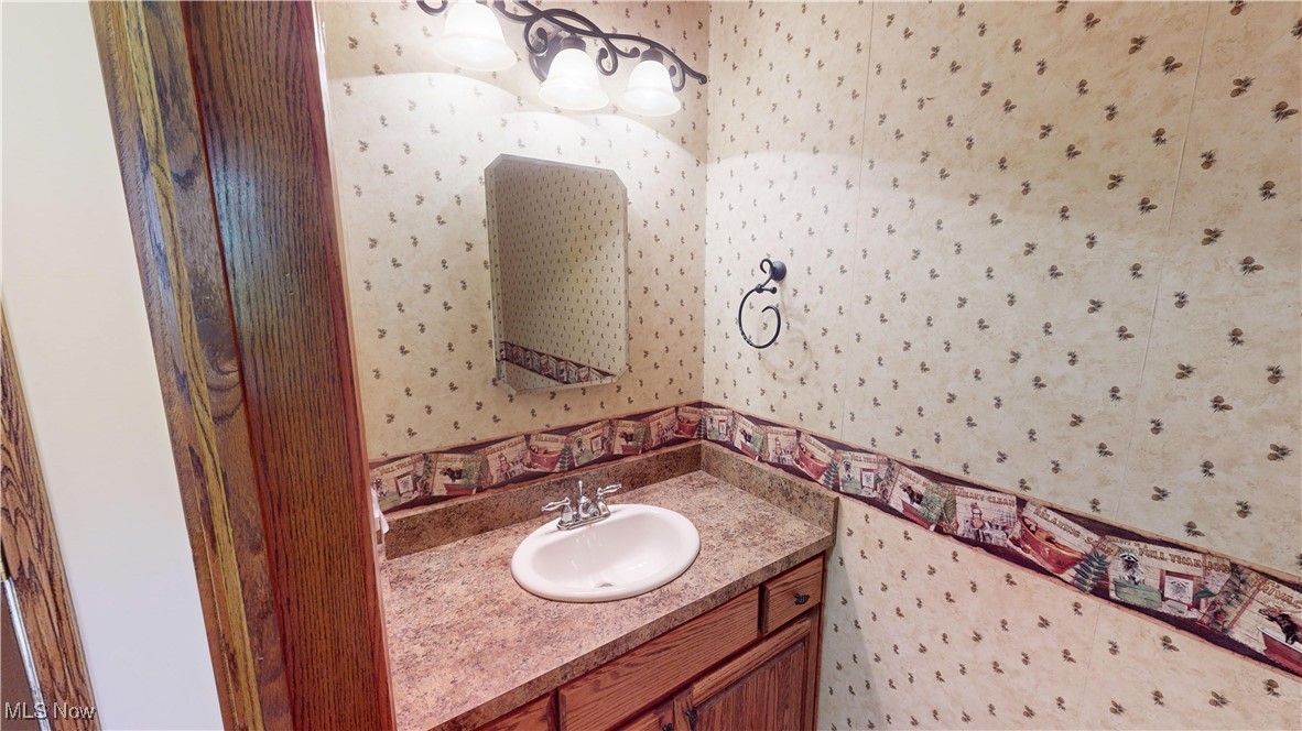 10323 Smith Road Litchfield, OH 44253 - Photo 16 of 50 Bathroom with wallpapered walls and vanity