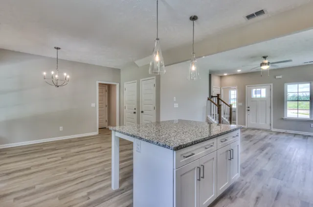 a kitchen with stainless steel appliances granite countertop wooden floors and granite counter tops