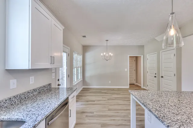a view of a kitchen cabinets kitchen island wooden floor and staircase