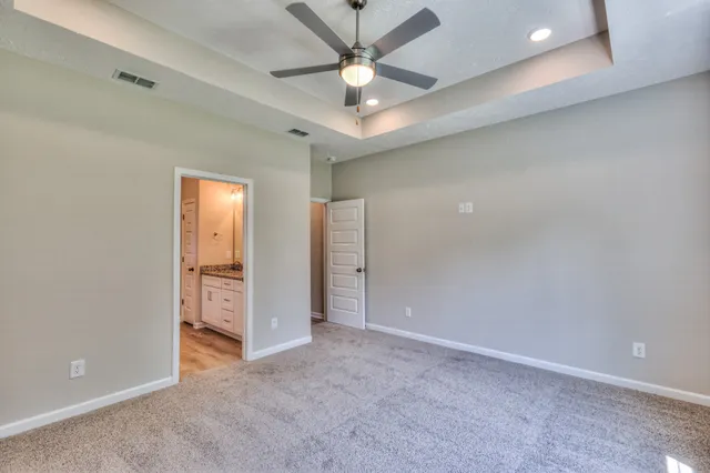 an empty room with closet and a chandelier fan