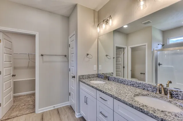 a bathroom with a granite countertop sink shower and a mirror