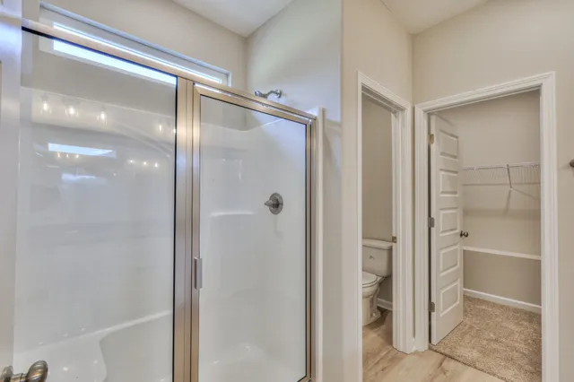 a bathroom with a glass shower door and a glass door