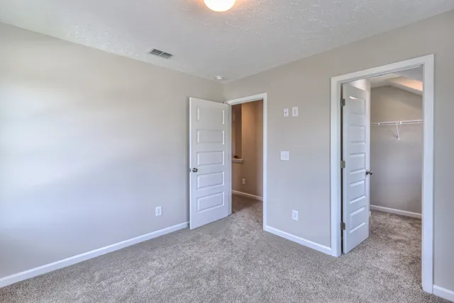 an empty room with closet and mirror