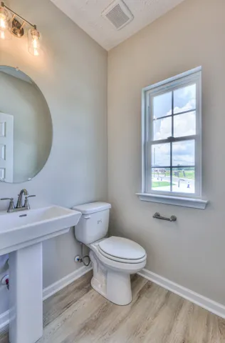 a bathroom with a sink toilet and window