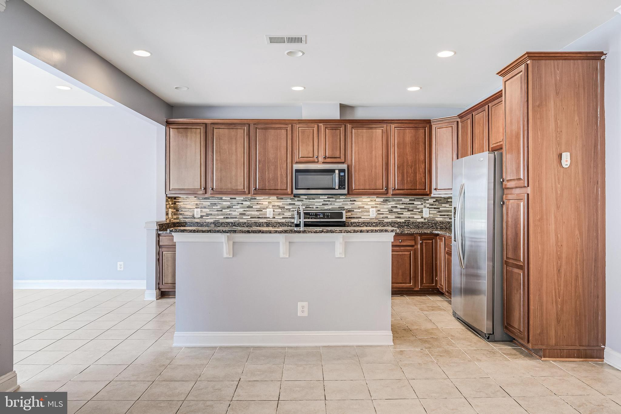 43583 White Cap Terrace Chantilly, VA 20152 - Photo 15 of 55 a kitchen with a refrigerator a microwave and cabinets