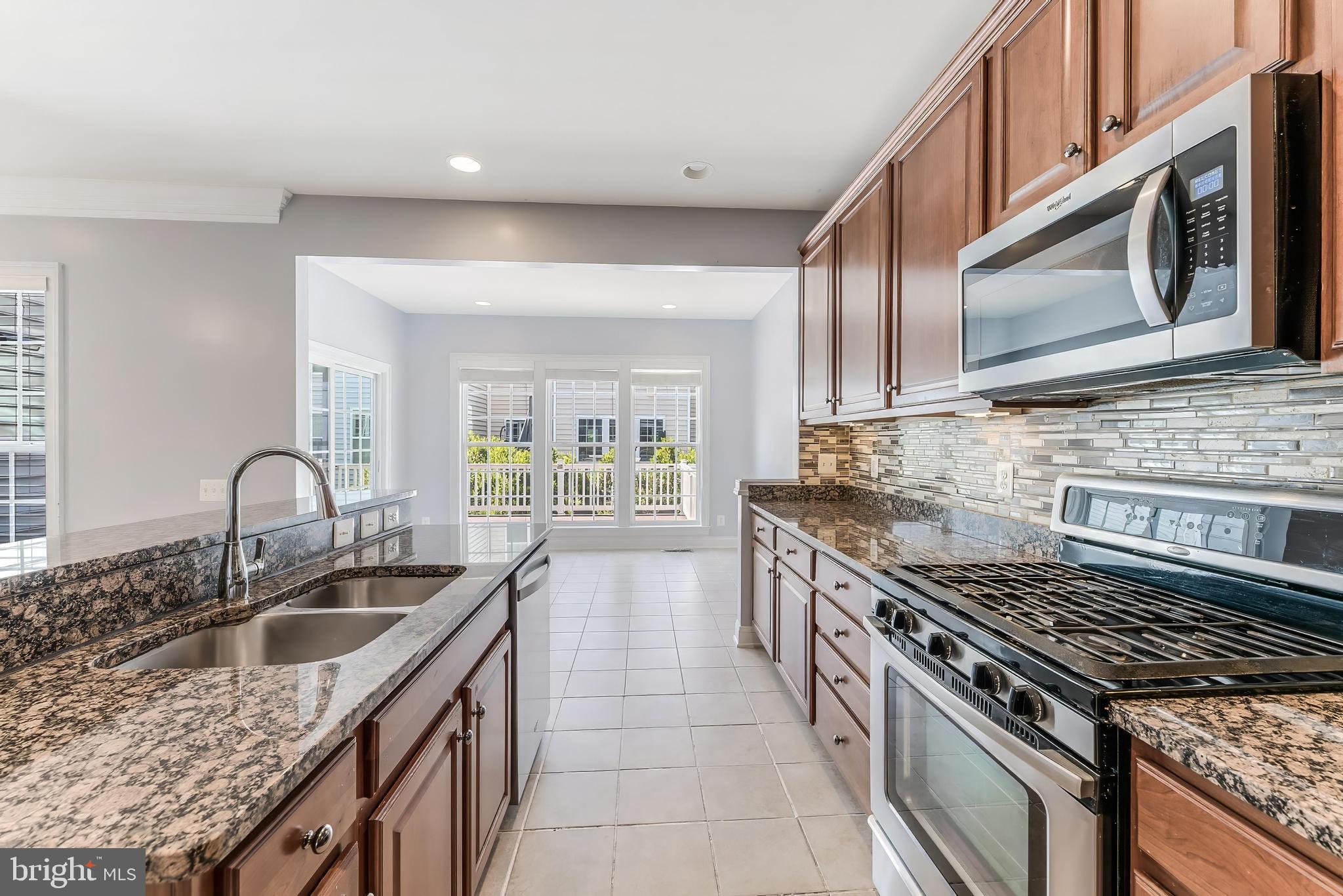 43583 White Cap Terrace Chantilly, VA 20152 - Photo 19 of 55 a kitchen with granite countertop a sink stove top oven and cabinets