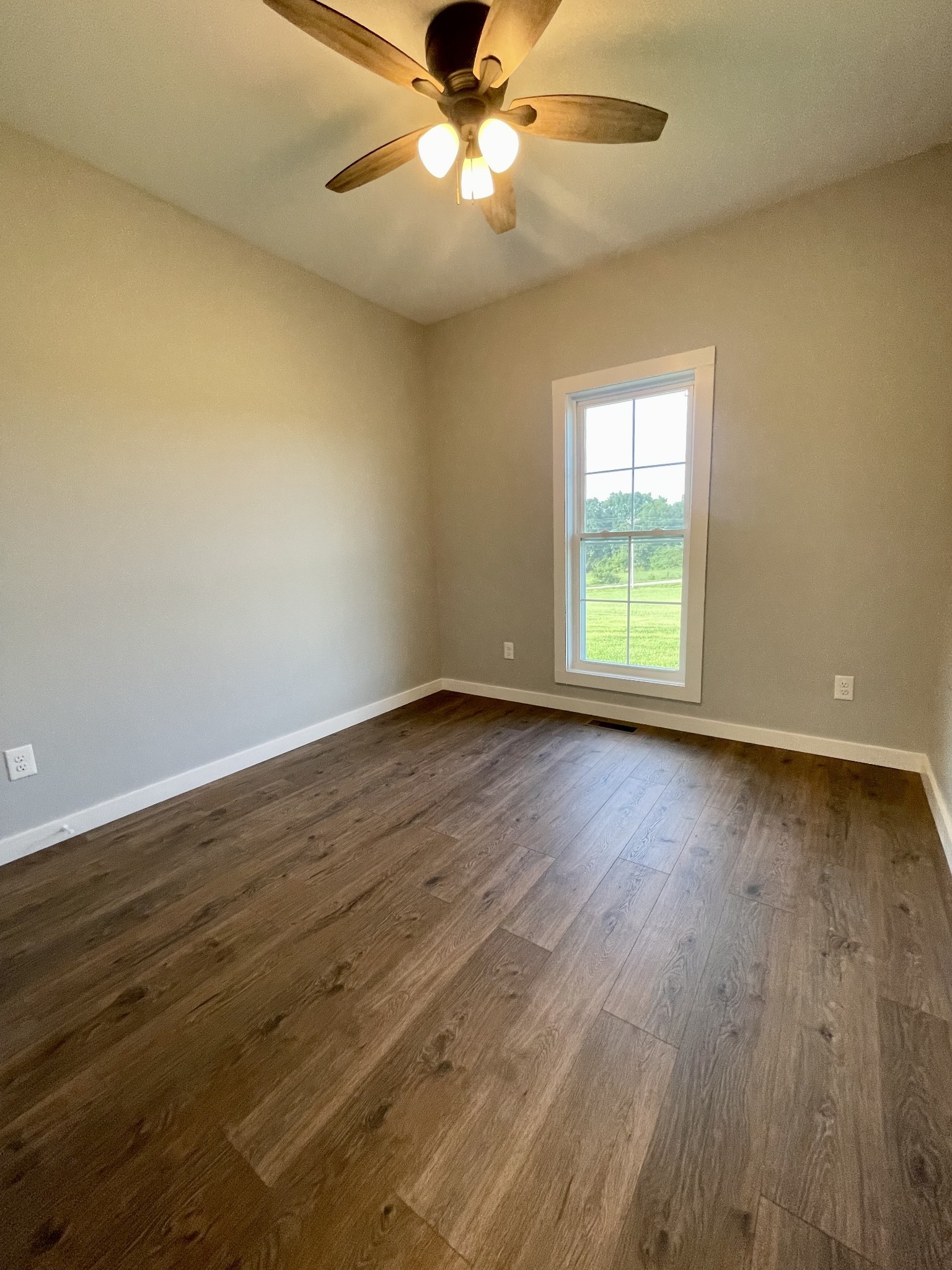 1456 Fall River Road Lawrenceburg, TN 38464 - Photo 21 of 30 a view of an empty room with wooden floor and a window