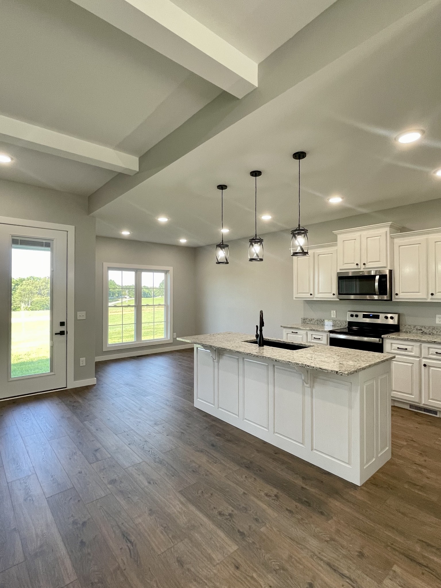 1456 Fall River Road Lawrenceburg, TN 38464 - Photo 6 of 30 a large kitchen with stainless steel appliances a large counter top a stove a sink and a window
