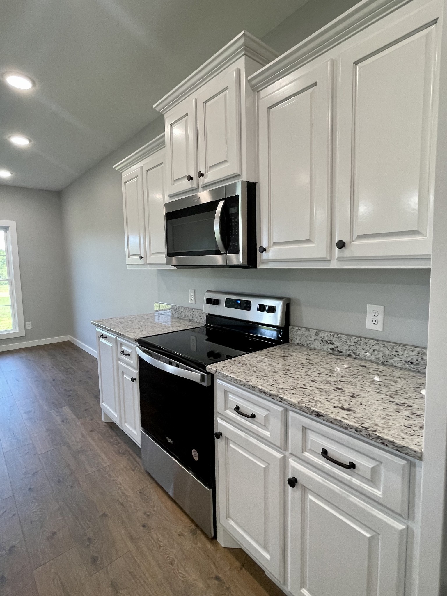 1456 Fall River Road Lawrenceburg, TN 38464 - Photo 8 of 30 a kitchen with granite countertop white cabinets and stainless steel appliances