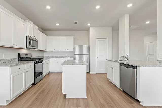 a kitchen with white cabinets and appliances