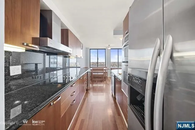 a kitchen with stainless steel appliances granite countertop a sink stove and refrigerator