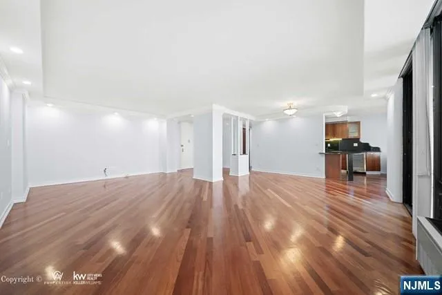 a kitchen with a table chairs refrigerator and wooden floor