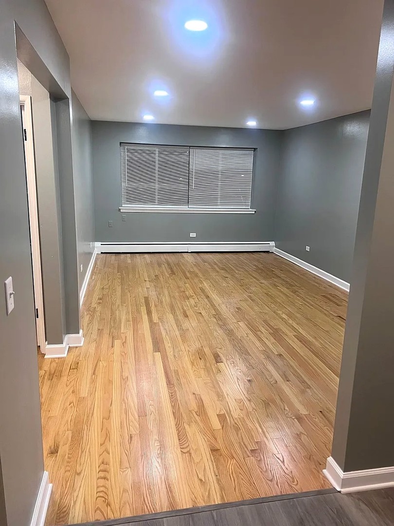 6619 North Sheridan Road, Unit 305 Chicago, IL 60626 - Photo 3 of 10 wooden floor in an empty room with a window