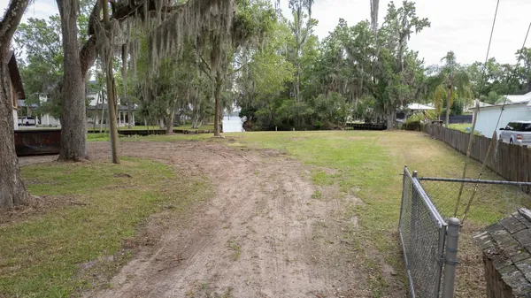 an aerial view of a house with a yard and lake view