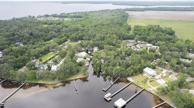 an aerial view of a house with a yard and lake view
