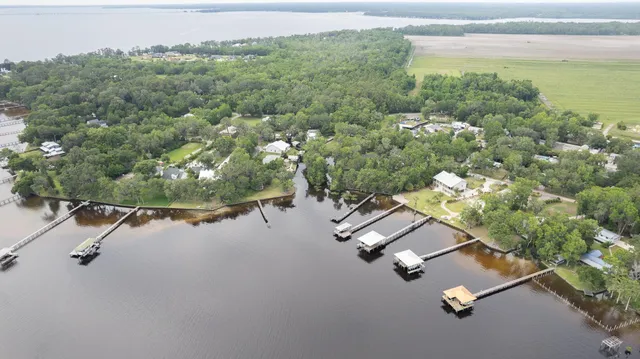 an aerial view of a house with a yard and lake view