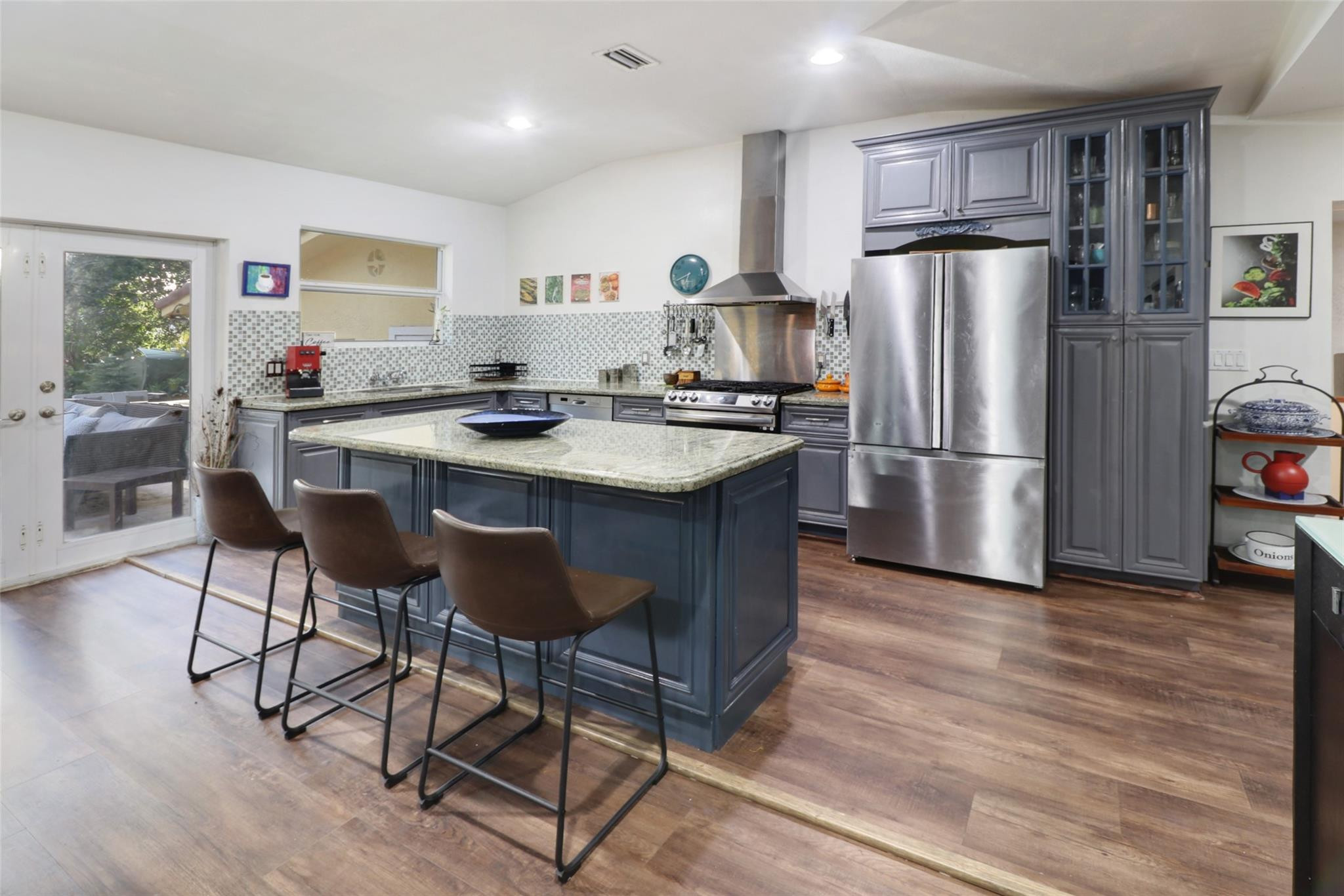 11410 Griffing Boulevard Miami, FL 33161 - Photo 11 of 42 a kitchen with stainless steel appliances granite countertop a refrigerator a stove a sink dishwasher a dining table and chairs with wooden floor
