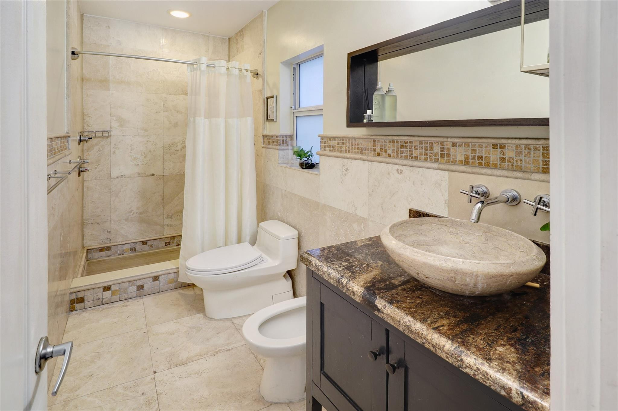 11410 Griffing Boulevard Miami, FL 33161 - Photo 17 of 42 a bathroom with a granite countertop sink a toilet a mirror and shower
